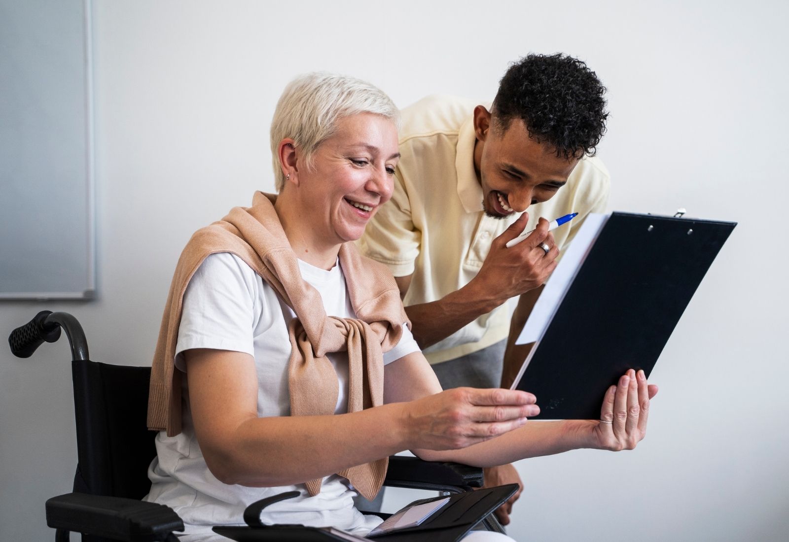 A Support Worker helps an NDIS Participant to complete their work.